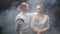 Two young women fencers in white protective suits talking to each other - leaning on the shoulder of the friend and