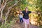 two young women friends hiking amateur, en route on a forest trail. hikers reaching the top. people on a trip.