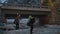 Two young women go on a rocky river with the backpacks and guitar under a bridge in the mountains