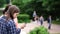 Two young women gossiping, looking in mobile phone in park. Concept of meeting of girlfriends.