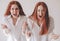 Two young women got angry and shout at the camera They feel rage, aggression, anger. Two red-haired sisters stand