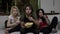 Two young women and a guy eating popcorn and watching horror film with fear grim on their face