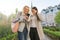 Two young women having fun, looking at the smartphone laughing, sunny autumn day, city background, golden hour