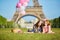 Two young women having picnic near the Eiffel tower in Paris, France