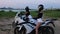 Two young women in helmets sitting on motorcycles and talking at early evening near the beach