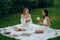 Two young women meditate and do yoga in nature.