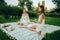 Two young women meditate and do yoga in nature.