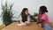 Two young women of mixed race lesbian couple sitting in their home and a black woman comforts a white woman who is depressed