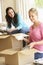 Two Young Women Moving Into New Home Unpacking Boxes