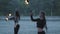 Two young women performing a show with flame balls standing on the riverbank. Skillful fireshow artists showing mastery