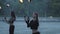 Two young women performing a show with flame balls standing on the riverbank. Skillful fireshow artists showing mastery