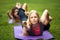 Two young women performs training for flexibility in the park