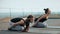 Two young women practicing hatha yoga on the roof, outdoors