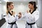 Two young women preparing for sparring and practicing taekwondo