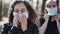 Two young women putting medical mask on face in wood. Close up of females protecting yourself from diseases on walk