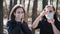 Two young women putting medical mask on face in wood. Close up of females protecting yourself from diseases on walk