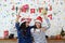 Two young women in Santa hats and holding gift boxes having fun