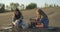 Two young women with snowboards sit in the sand smiling hugging and sandboarding 4K Slow Motion portrait. Lesbian LGBT