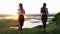 Two young women in sports clothes jogs around the field at early sunset