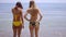 Two young women in swimsuits standing in the sea