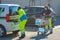 Two young women in uniform volunteer buying groceries. Girls loading car with food and water supplies.Yellow gillet,face mask on