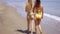 Two young women walking away along a beach
