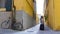 Two young women walking through the narrow yellow streets with luggage