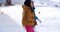 Two young women walking through snow at a resort