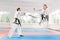 Two young women wearing in kimono and black belt training karate martial arts.