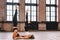 Two youngfemale do complex of stretching yoga asanas in loft style class. Shirshasana position.