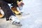 Tying laces of ice hockey skates skating rink