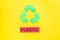 Types of matherial for reycle and reuse. Printed word plastic near eco symbol recycle arrows on yellow background top