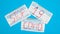 Typical 3-ply white surgical mask with rubber earhooks to cover mouth and nose with English block letters Stop Covid-19 on a blue