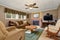 Typical American living room with brown couch and fireplace.