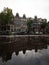 Typical Amsterdam architecture street houses reflection in rain water puddle city center Holland Netherlands