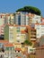 Typical apartment building in pastel colors on a big hill with viewpoint in Lisbon, Portugal