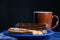 Typical Argentine churros with a cup of coffee on dark background