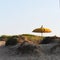 Typical Balinese sun umbrella standing on the beach. Salento, Italy