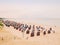 Typical beach basket chairs on sandy beach. Shallow blue sea, sunny day