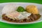 Typical Brazilian dish, diced meat, rice, cabbage and fried egg,green background