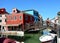 Typical brightly colorful houses and narrow channels with tourists in Burano, Venice, Italy