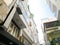 Typical caged-balcony apartment and multistory residential houses at small back alley in downtown Hanoi, Vietnam, lookup view