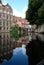 Typical canal scene in Bruges / Brugge, Belgium showing medieval buildings overlooking the water