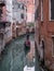 Typical canal scene in Venice with gondola and reflection in the water.