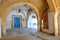 Typical cobbled and narrow street with colorful doors, columns and arcades inside the historical medina of Tunis