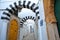 Typical cobbled and narrow street with colorful doors, columns and arcades inside the historical medina of Tunis