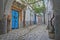 Typical cobbled and narrow street with colorful doors, columns and arcades inside the historical medina of Tunis