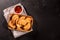 Typical Colombian empanadas served with spicy sauce on black background