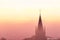 A typical colorful Autumn sunrise in Maastricht with the landscape covered with a layer of fog, leaving only silhouettes visible i