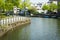 Typical Dutch canal landscape with water, trees, grass and boat